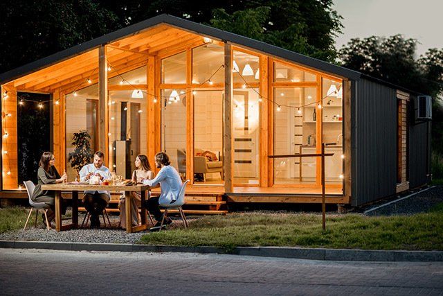 Landscaping Lighting — House With People Sitting At The Table in Raleigh, NC Landscaping Lighting — House With People Sitting At The Table in Raleigh, NC
