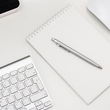 agenda con penna vicino a una tastiera 