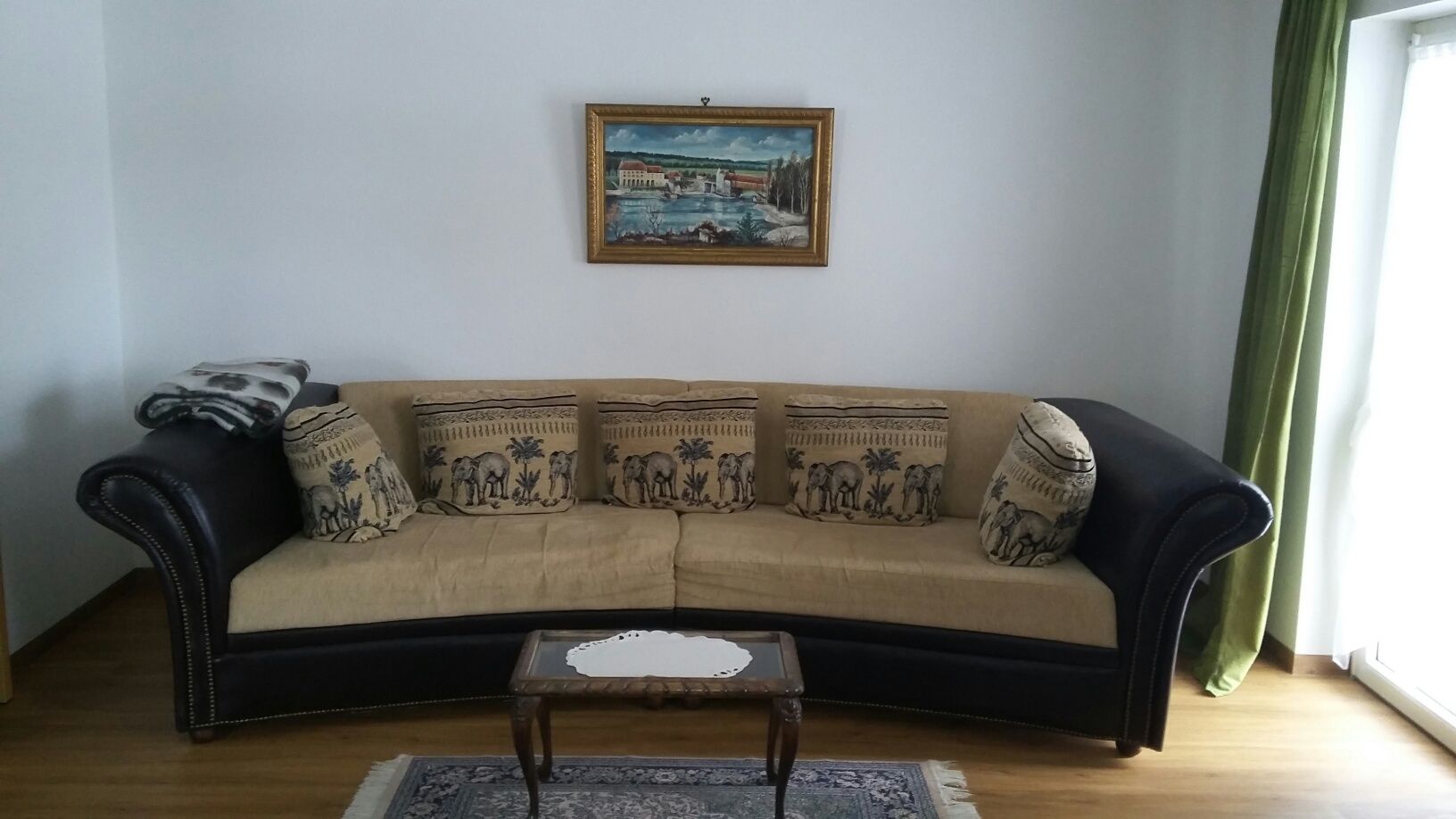 Ein Wohnzimmer mit einer Couch und einem Gemälde an der Wand