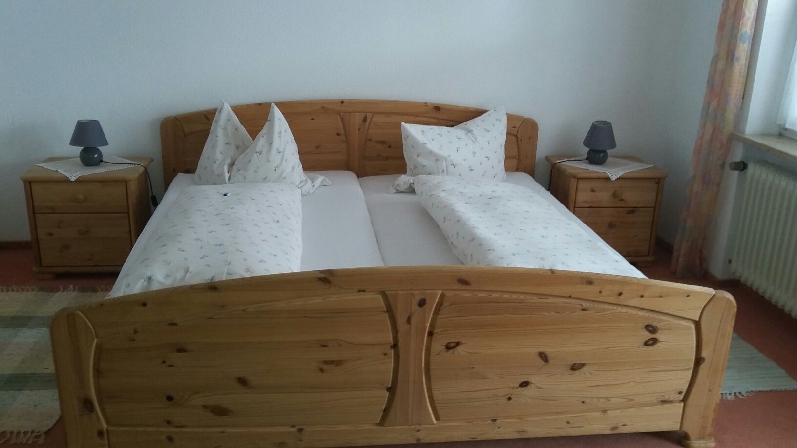 Ein Schlafzimmer mit einem Holzbett und zwei Nachttischen.