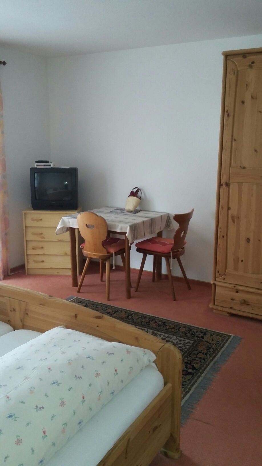 Ein Schlafzimmer mit einem Bett, einem Tisch und Stühlen und einem Fernseher