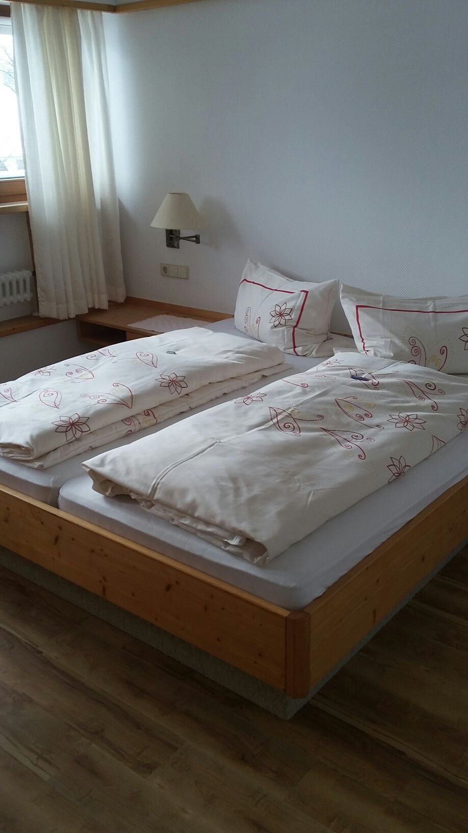 Ein Schlafzimmer mit zwei Betten und einem Fenster.