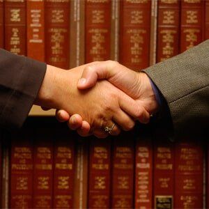 I Need A Lawyer — Handshake With Law Books in Background in North Attleborough, MA I Need A Lawyer — Handshake With Law Books in Background in North Attleborough, MA