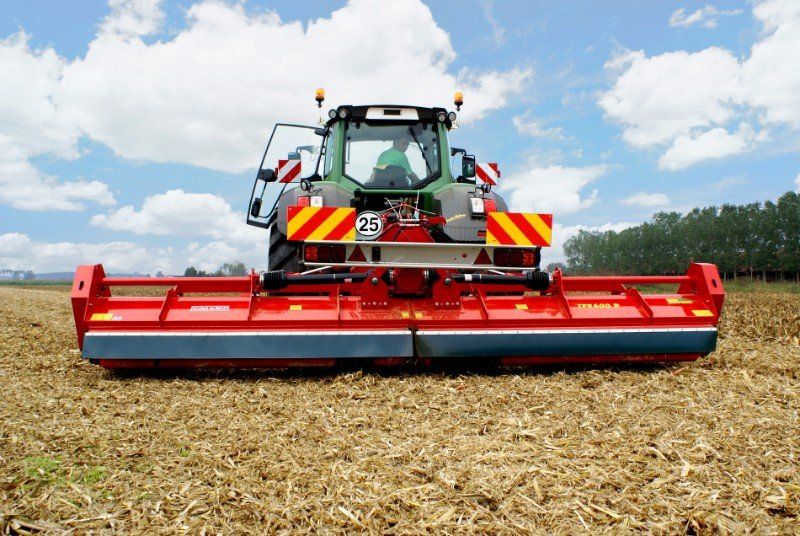 Ein Traktor mit angebautem Pflug pflügt ein Feld.