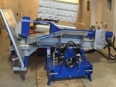 Eine blau-silberne Maschine steht auf einem Holzboden.