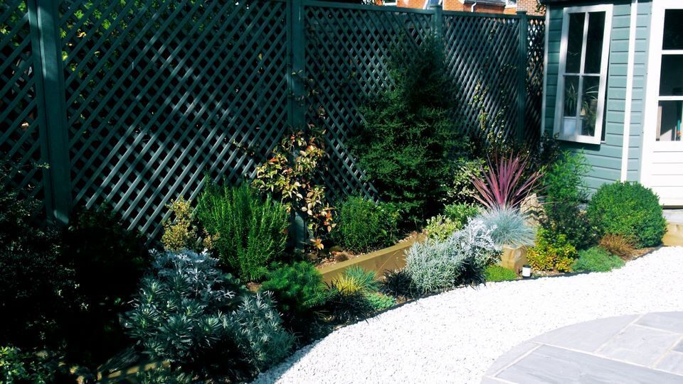 intricate wooden fence with flowers in a backyard garden
