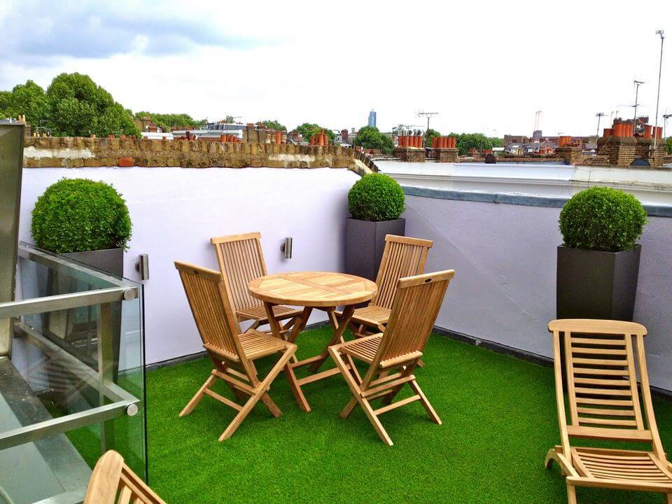 wooden table and chairs in a small roof garden