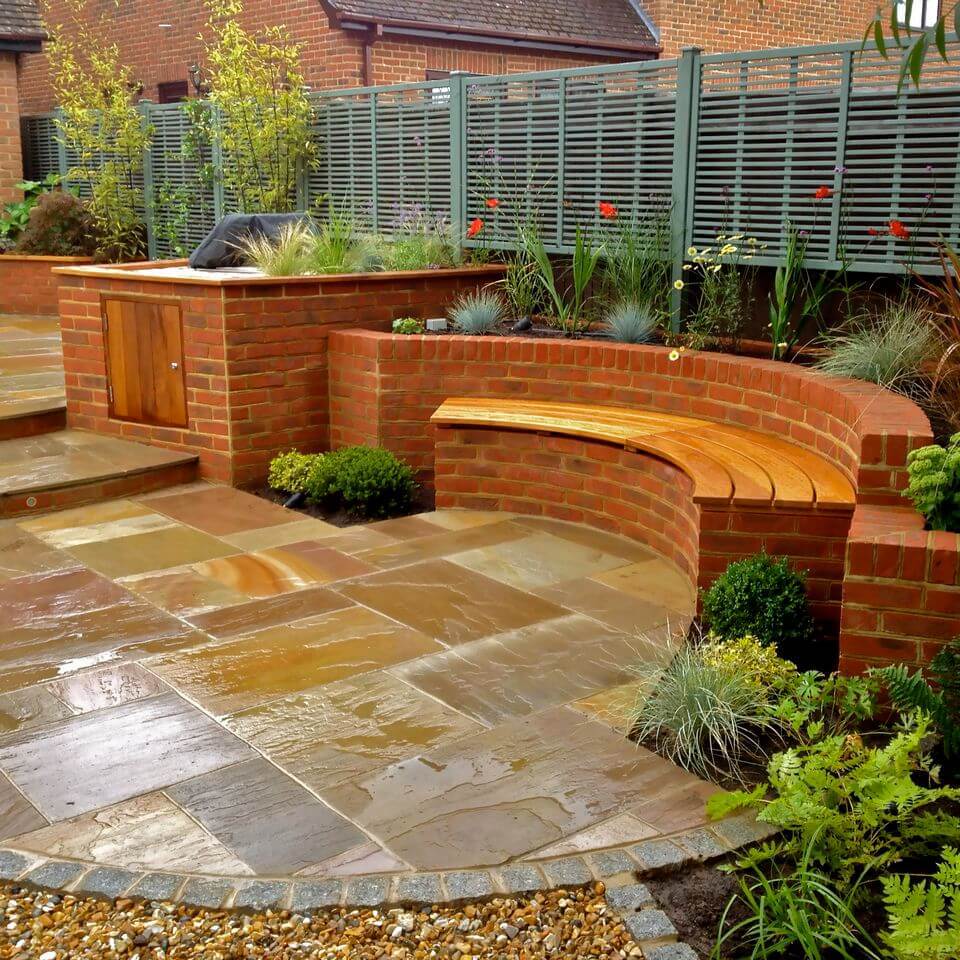 wooden bench in the center of a paved garden