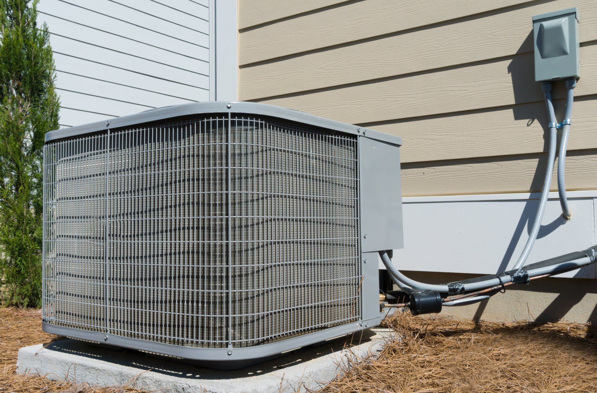 An air conditioner is sitting on the side of a house.