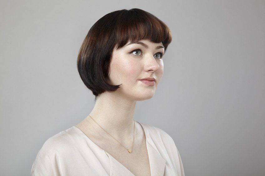 Tight simple studio portrait of confident young woman