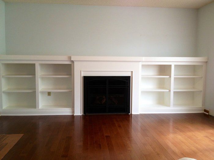 White shelving and a wood burning fireplace