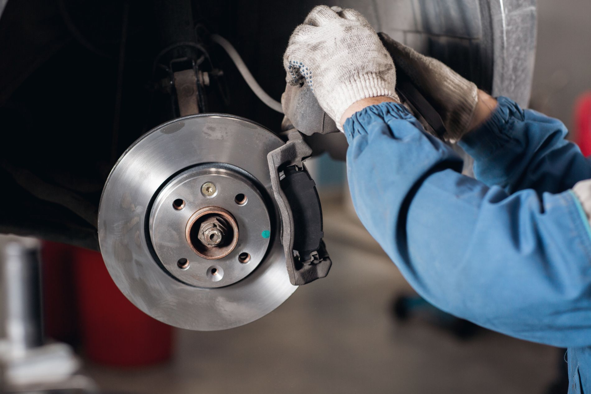 Technician removing a brake rotor during brake pad and rotor replacement in Cincinnati, OH