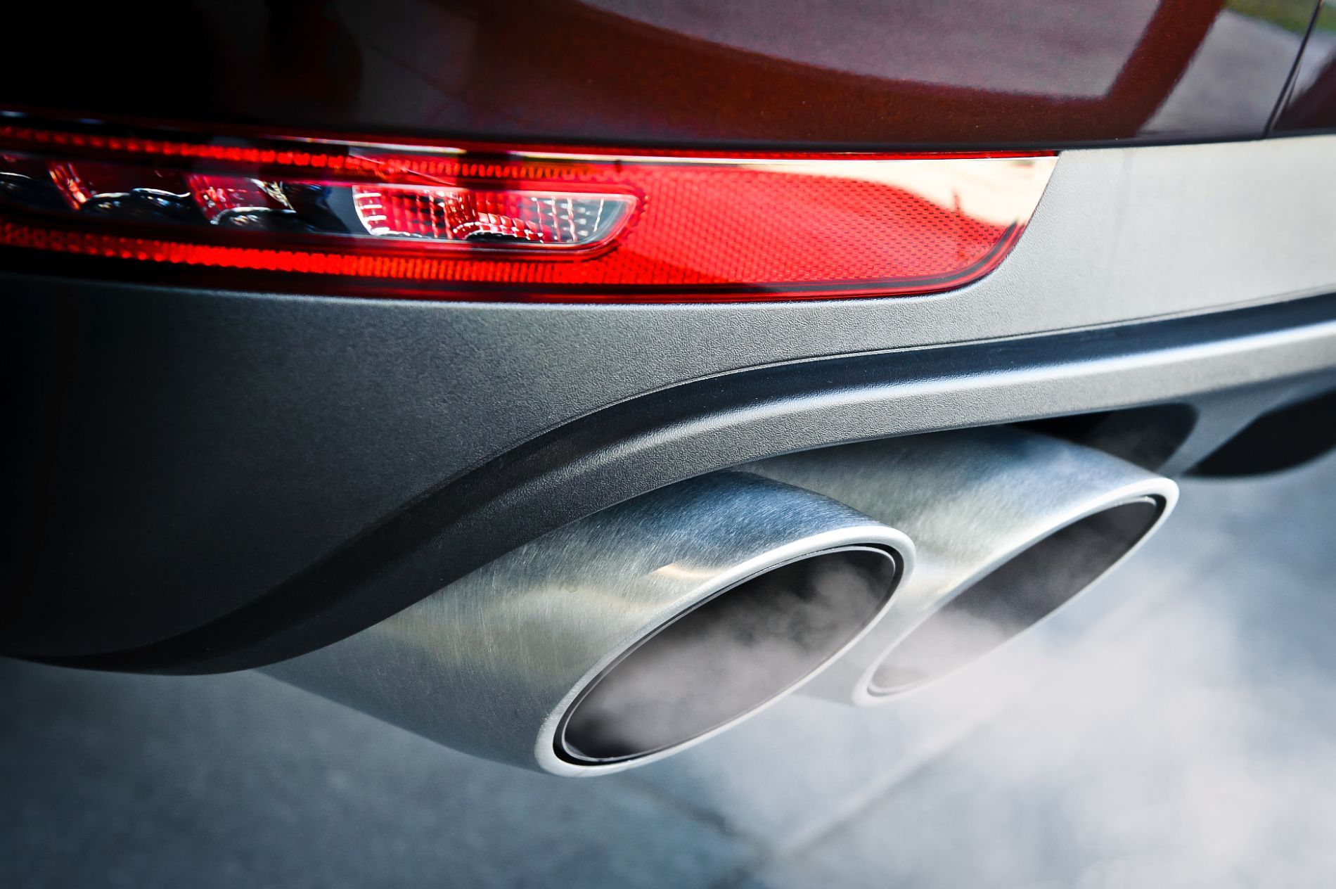Close-up of dual exhaust pipes emitting fumes, exhaust system repair and muffler service in Cincinnati, OH
