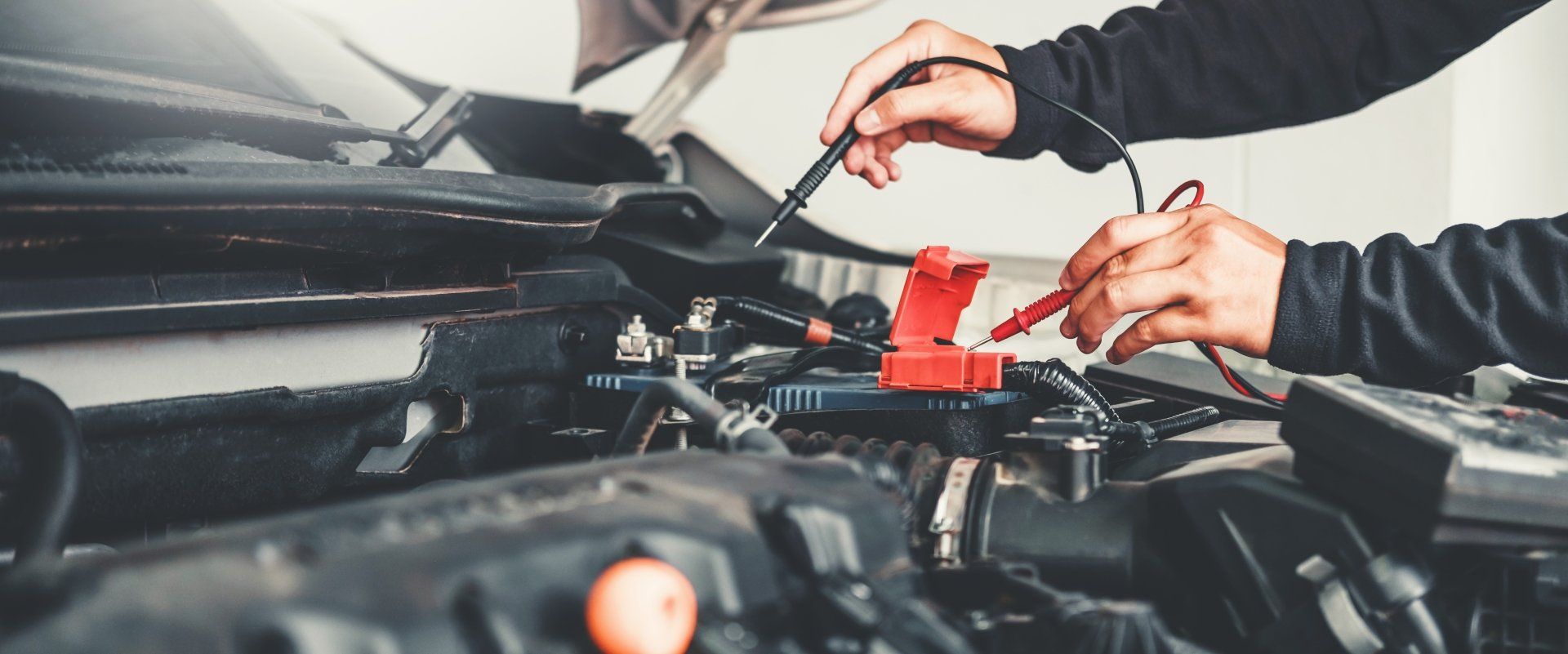 Mechanic using diagnostic equipment on a car engine, auto service specials in Cincinnati, OH