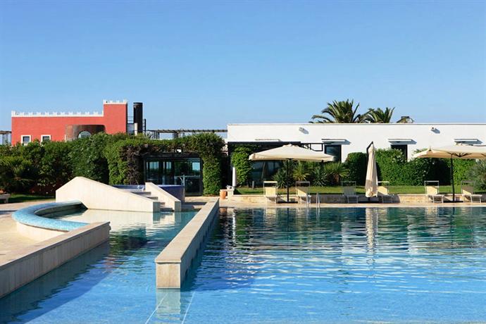 Una grande piscina con ombrelloni di fronte ad un edificio