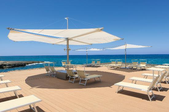 Una spiaggia con sedie a sdraio e ombrelloni