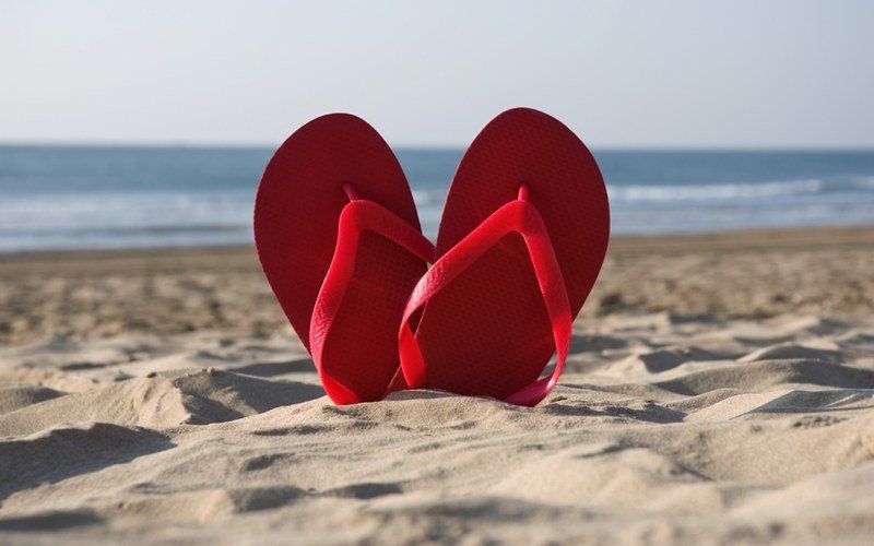 Un paio di infradito rosse sulla spiaggia