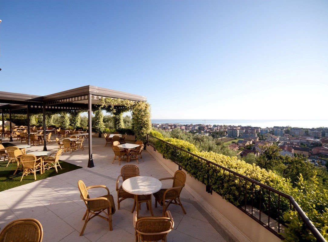 Un patio con tavoli e sedie e vista sul mare