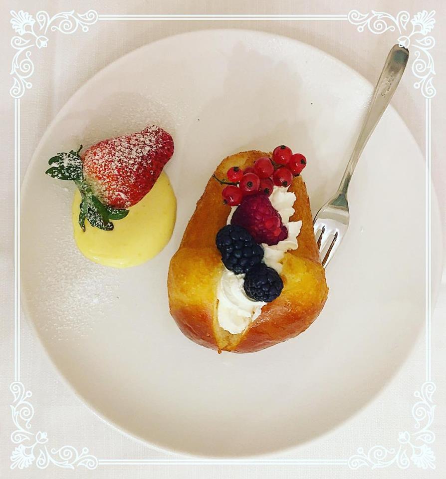 babà ripieno con panna e frutti di bosco