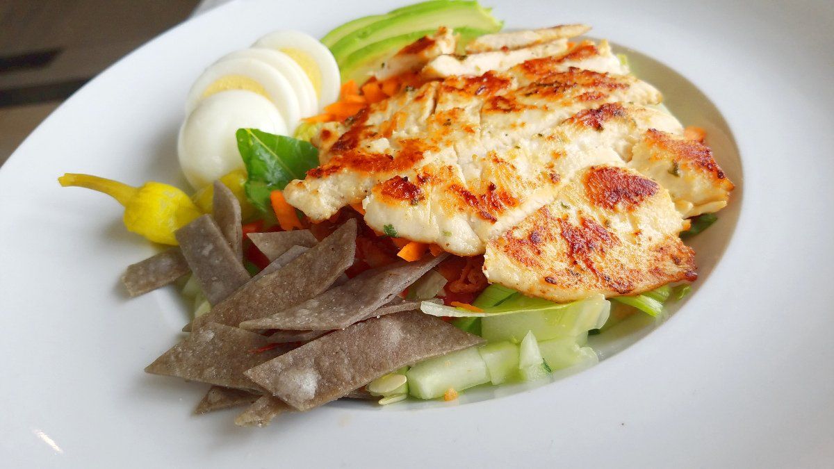 photo of chicken over salad