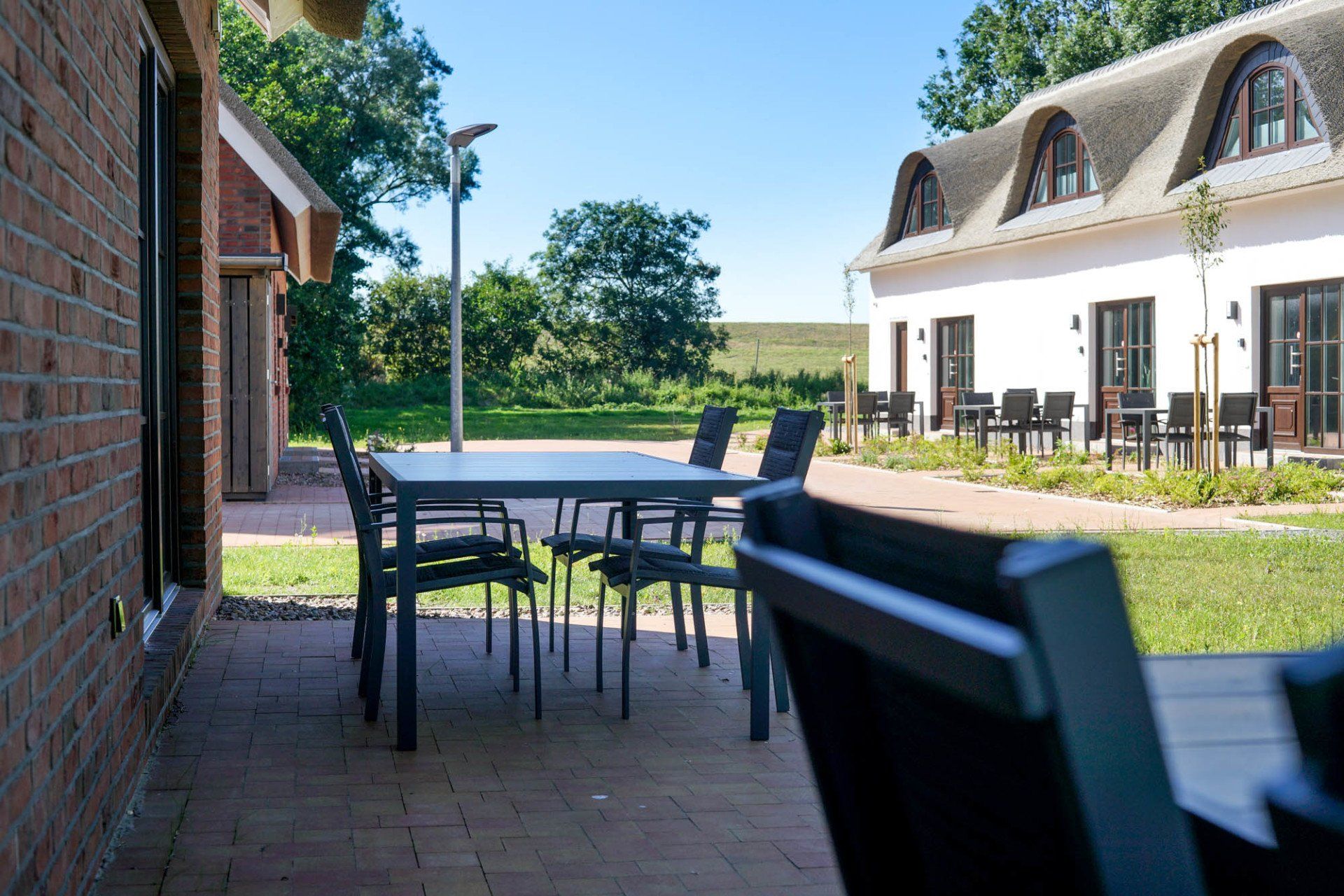Terrasse mit Blick auf Rasenfläche und Ferienhaus.