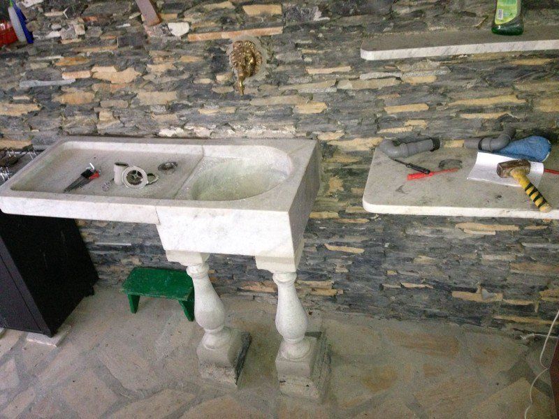 muro a secco con lavabo e mensole in marmo