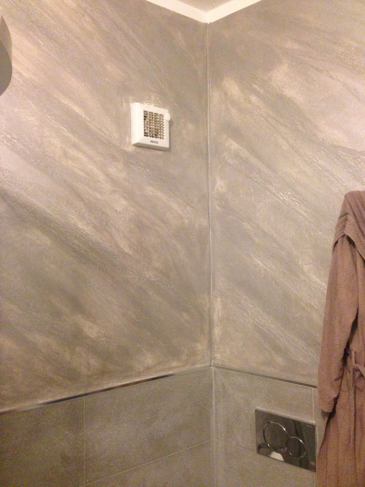 Angolo del bagno nei toni del grigio e del bianco con pareti decorative, uno sfiatatoio e un appendiabiti.
