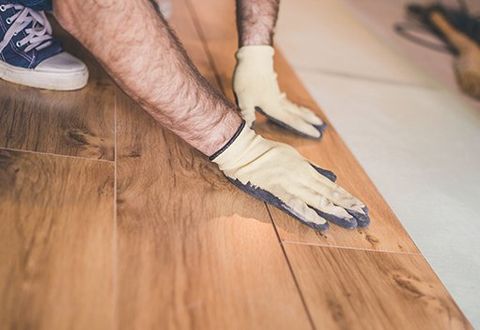 Worker Installation of Vinyl Flooring — Port St. Lucie, FL — Gotcha Covered Flooring Worker Installation of Vinyl Flooring — Port St. Lucie, FL — Gotcha Covered Flooring