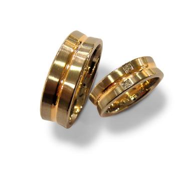 Ein paar goldene Ringe auf weißem Hintergrund