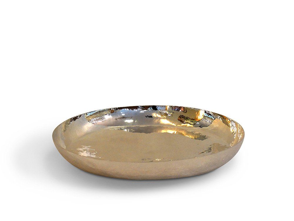 Auf einer weißen Oberfläche liegt eine goldene Platte.