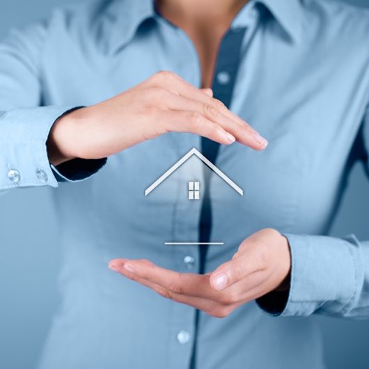 Hands covering a house