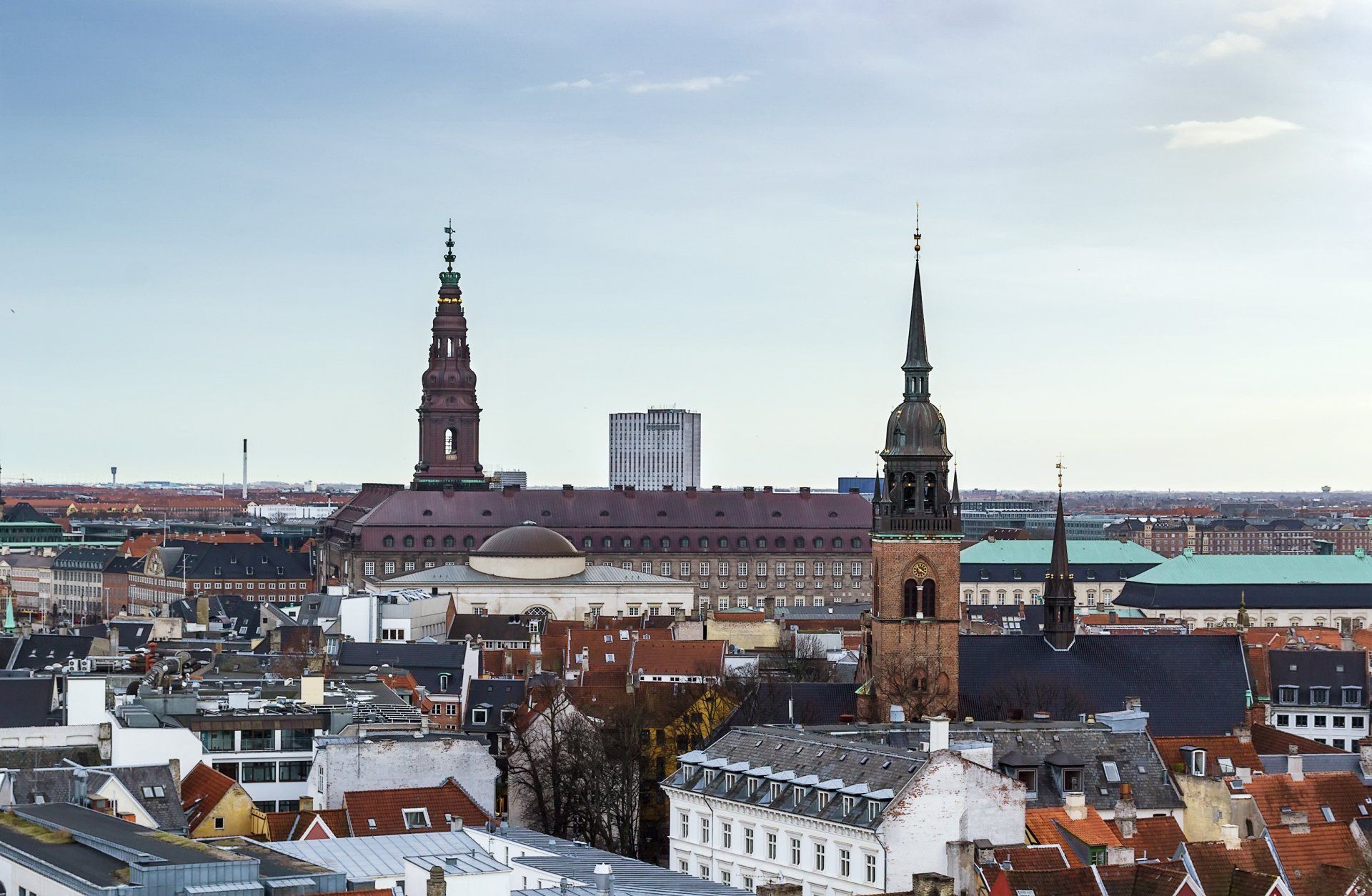 Panoramaudsigt over bybilledet med historiske tårne ​​og hustage under en bleg himmel