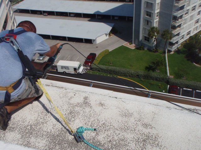 Man Installing Gutter On Building — Oakland Park, FL — Watertite Gutter Company