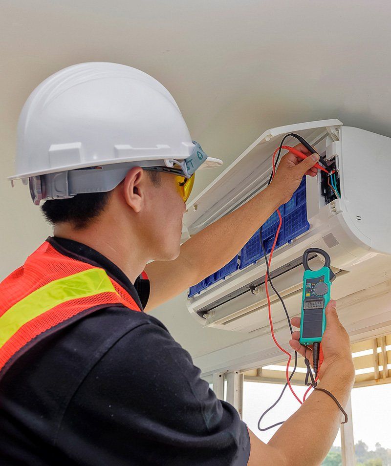 Man Fixing Air Conditioner — Sheffield, AL — Glasgow Heating & Air Conditioning Man Fixing Air Conditioner — Sheffield, AL — Glasgow Heating & Air Conditioning