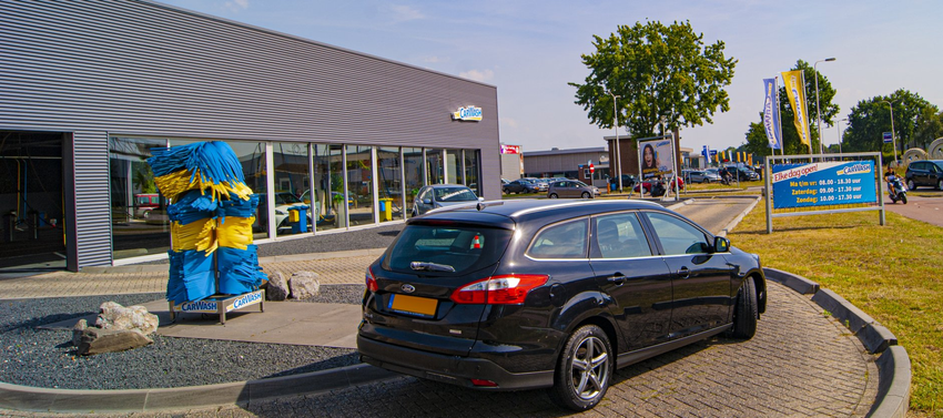 Afbeelding van een auto die uit de wasstraat rijdt