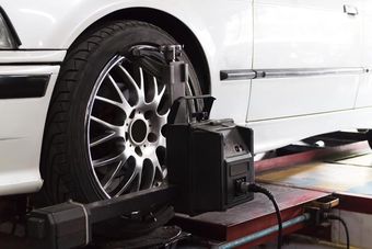 Wheel Alignment image of a black tire and a white car