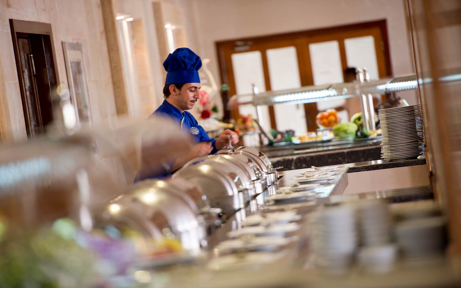 Professional chef presenting dishes at the open kitchen counter.