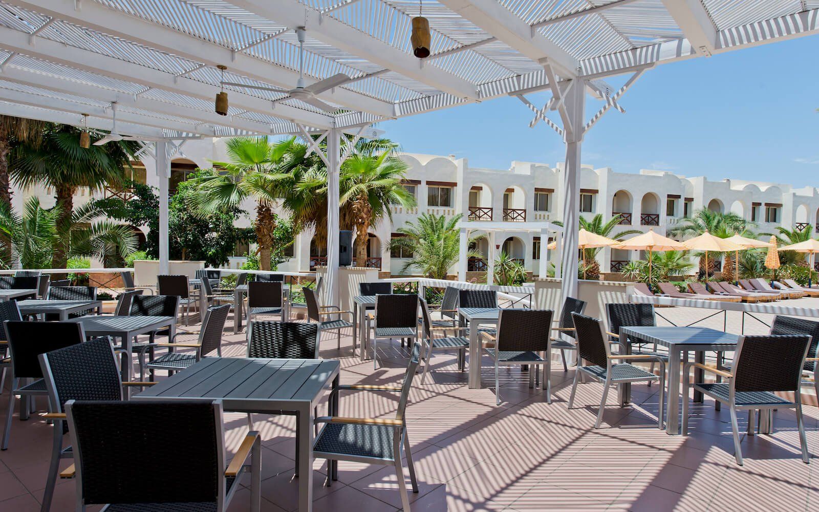 Outdoor restaurant seating with a view of the pool and elegant decor.