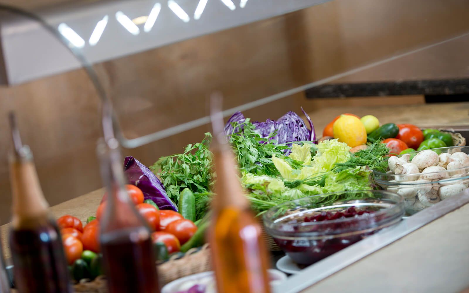 Plates of fresh food including vegetables and salads served at the buffet. 