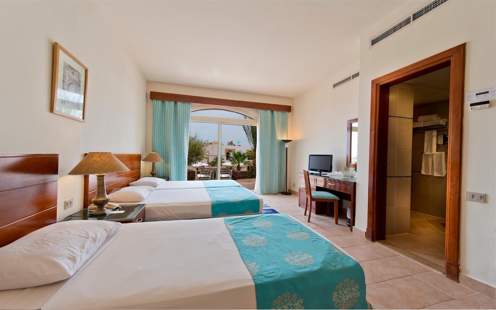 Modern guest room with elegant furnishings and natural sunlight.