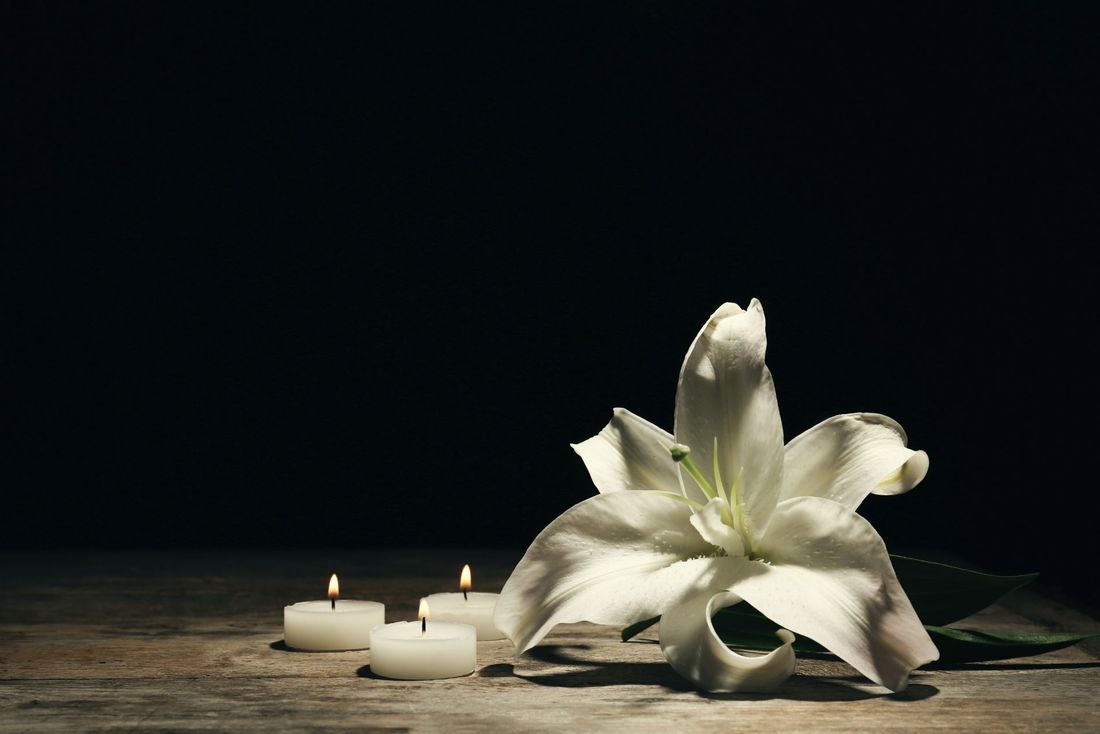 Delle candele accese e un fiore