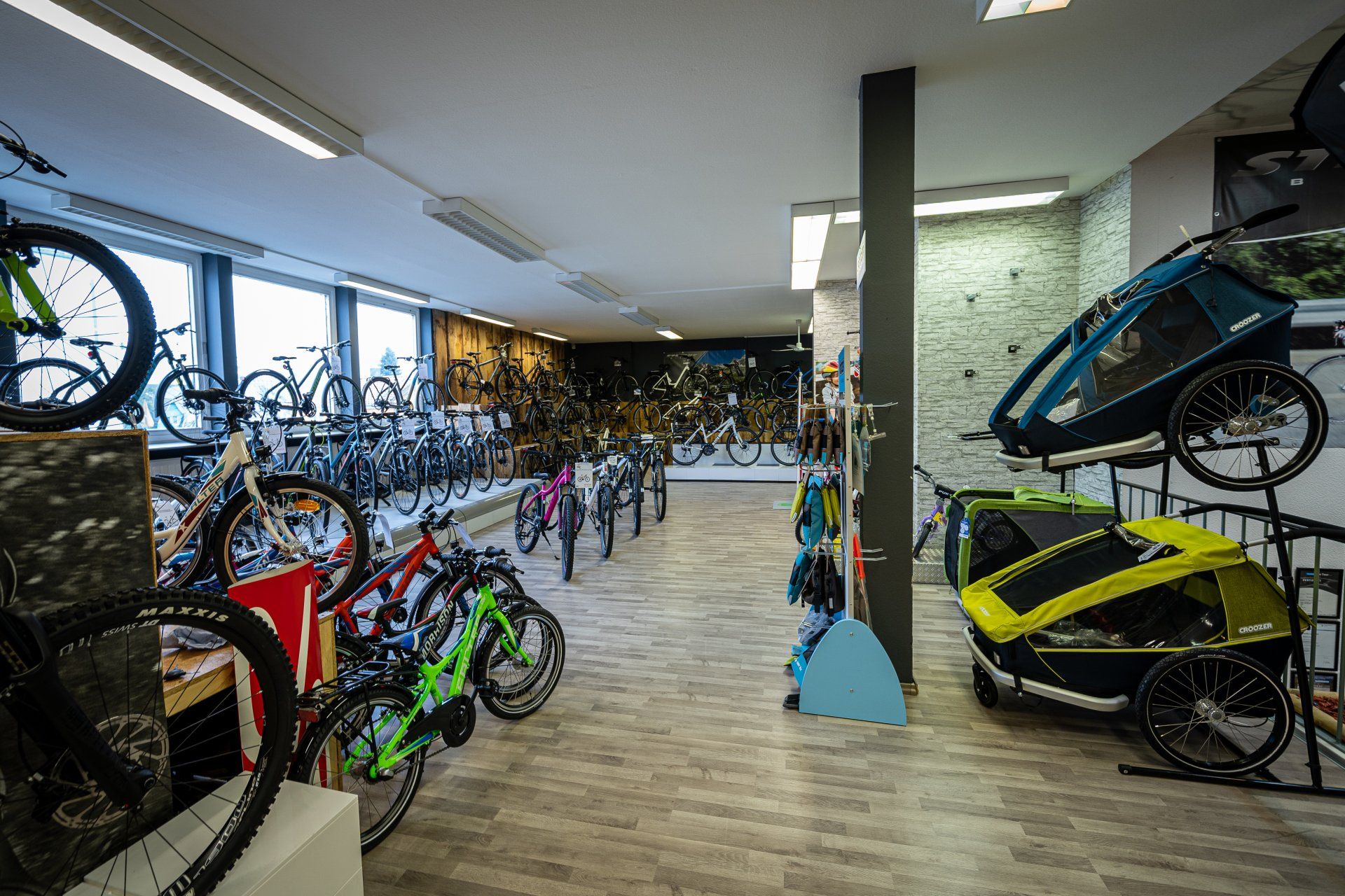 A room filled with lots of bicycles and a trailer.