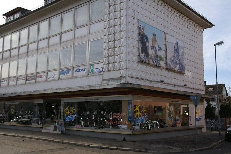 A large building with a bicycle shop on the side of it