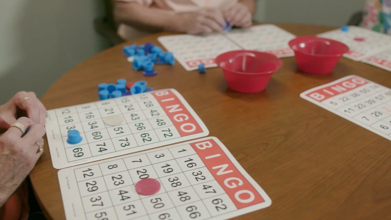 Two people are sitting at a table playing bingo.