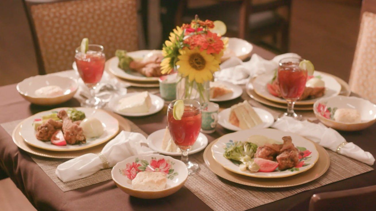 A table topped with plates of food and glasses of wine.
