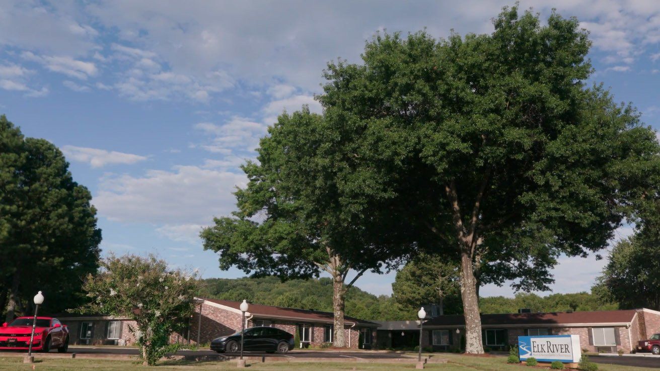 A row of houses with trees in front of them in a residential area.