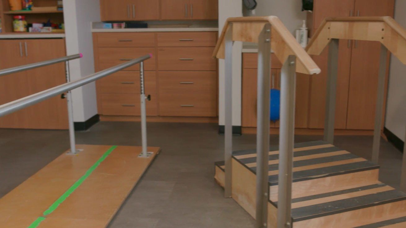A room with stairs and a green tape on the floor