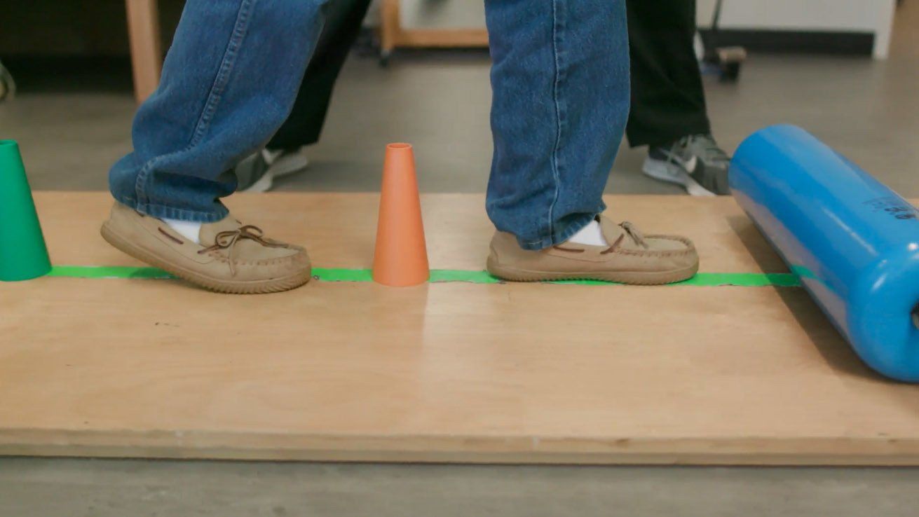 A person is standing on a wooden board with cones on it.