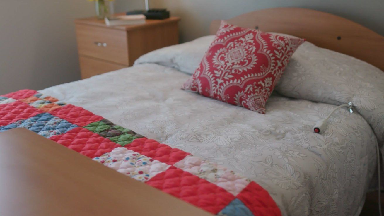A bed with a quilt and a pillow on it