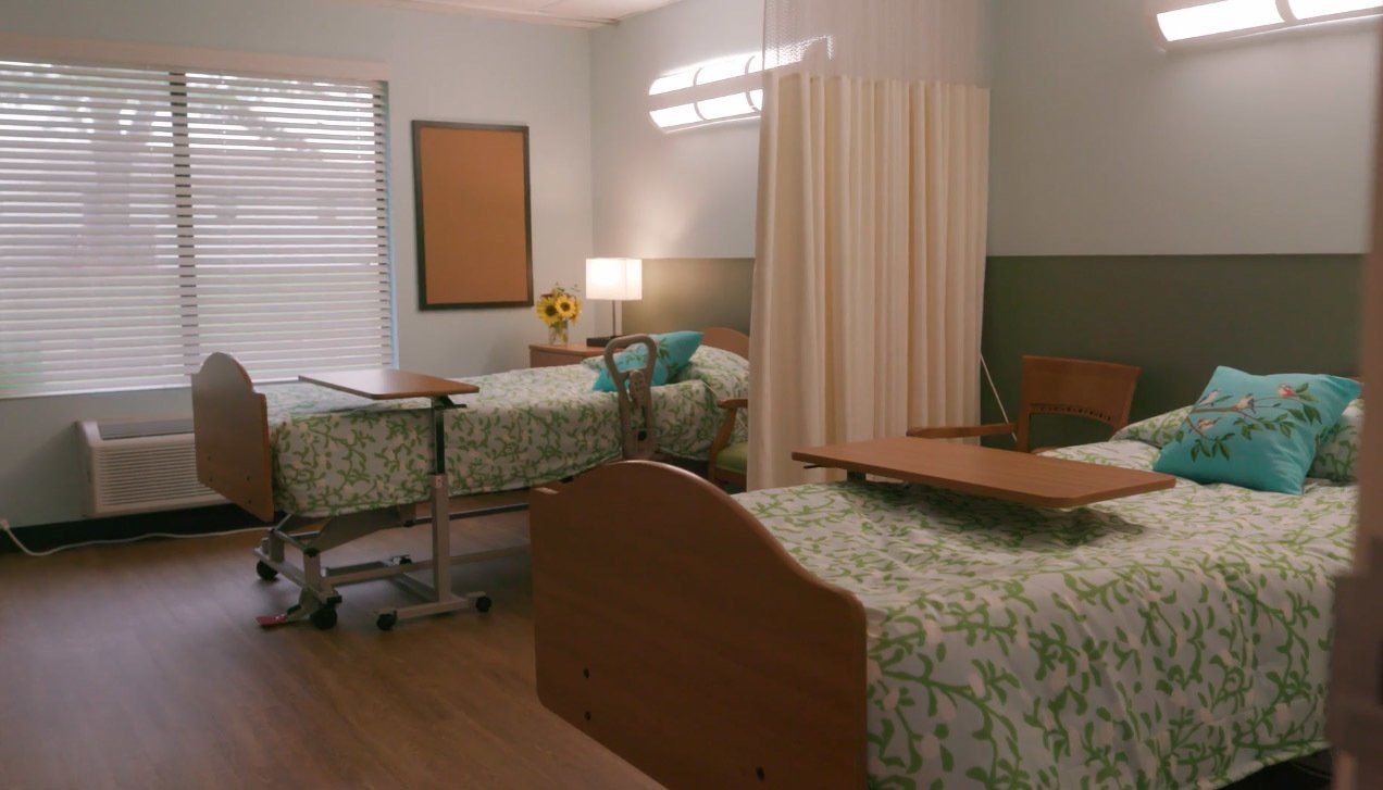 A hospital room with two beds and a table.